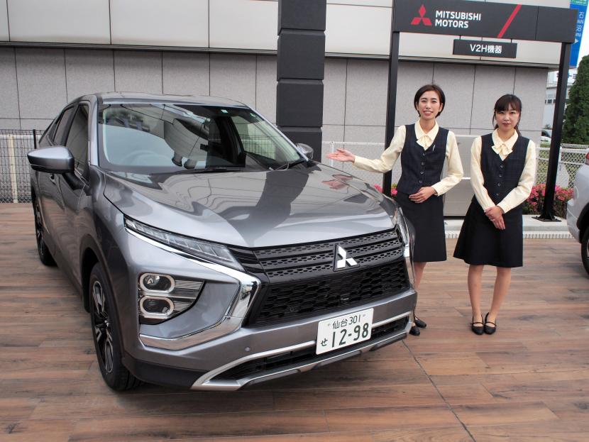 電気自動車「エクリプス　クロスPHEV」の特長を説明する女性スタッフ＝仙台市宮城野区の宮城三菱自動車販売日の出町店