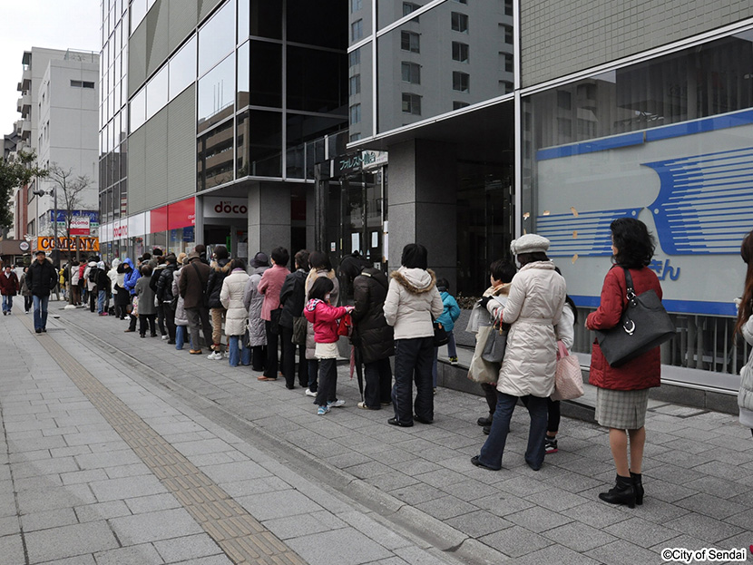 画像：スーパーの開店を待つ市民