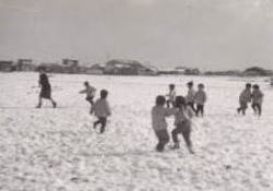 雪に喜んではしゃぐ子どもたちの写真